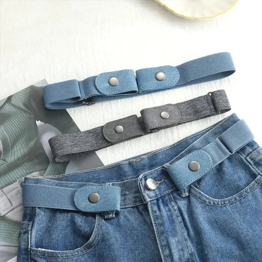 Light blue no-buckle belt fastened around the front belt loops of jeans, with blue and gray belts above