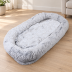 Gray human-size dog bed; product photo in an AI-generated living-room setting